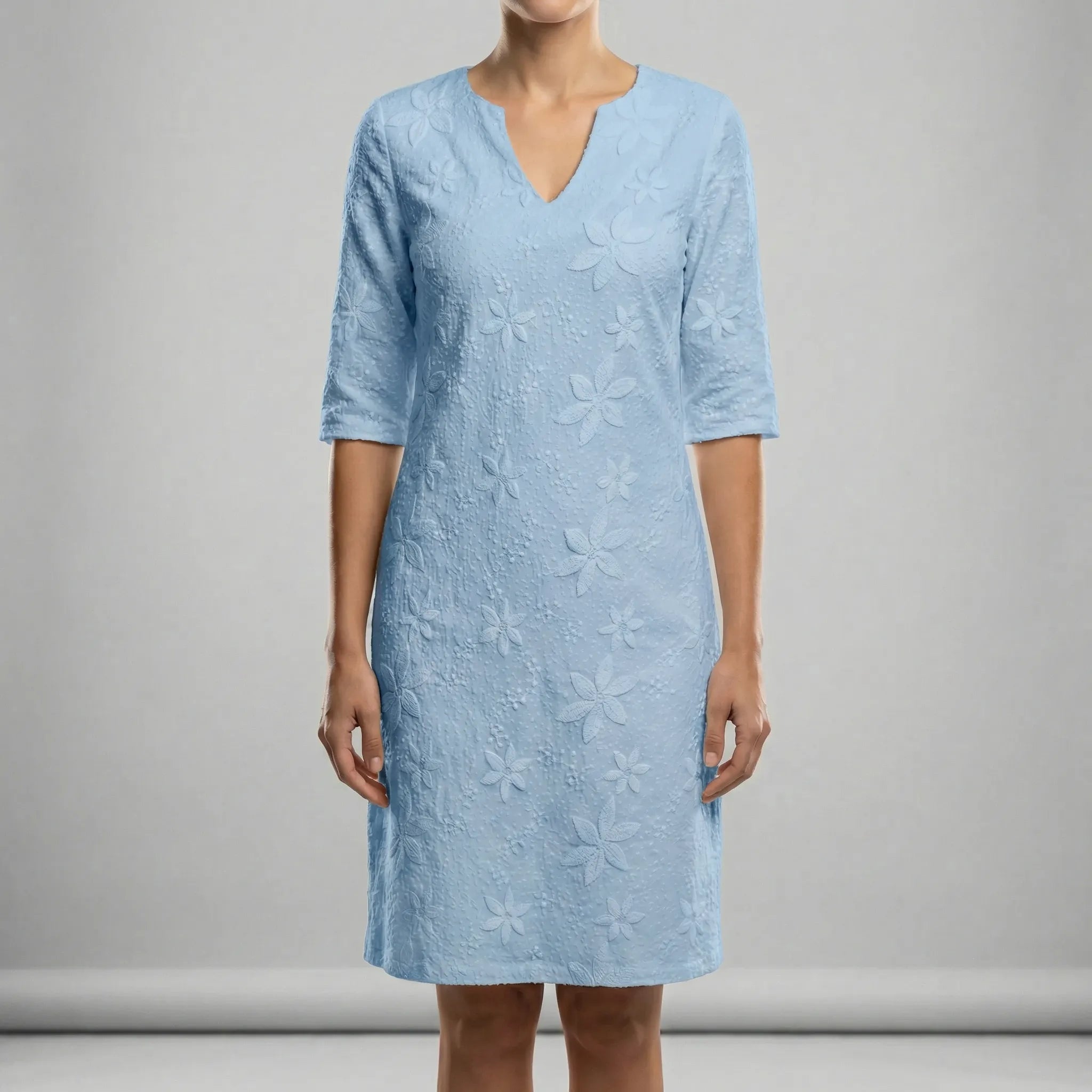 Light blue dress with floral patterns on a gray background