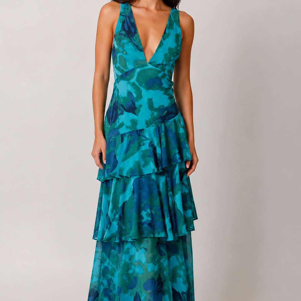 Woman wearing a teal and blue patterned dress on a plain background