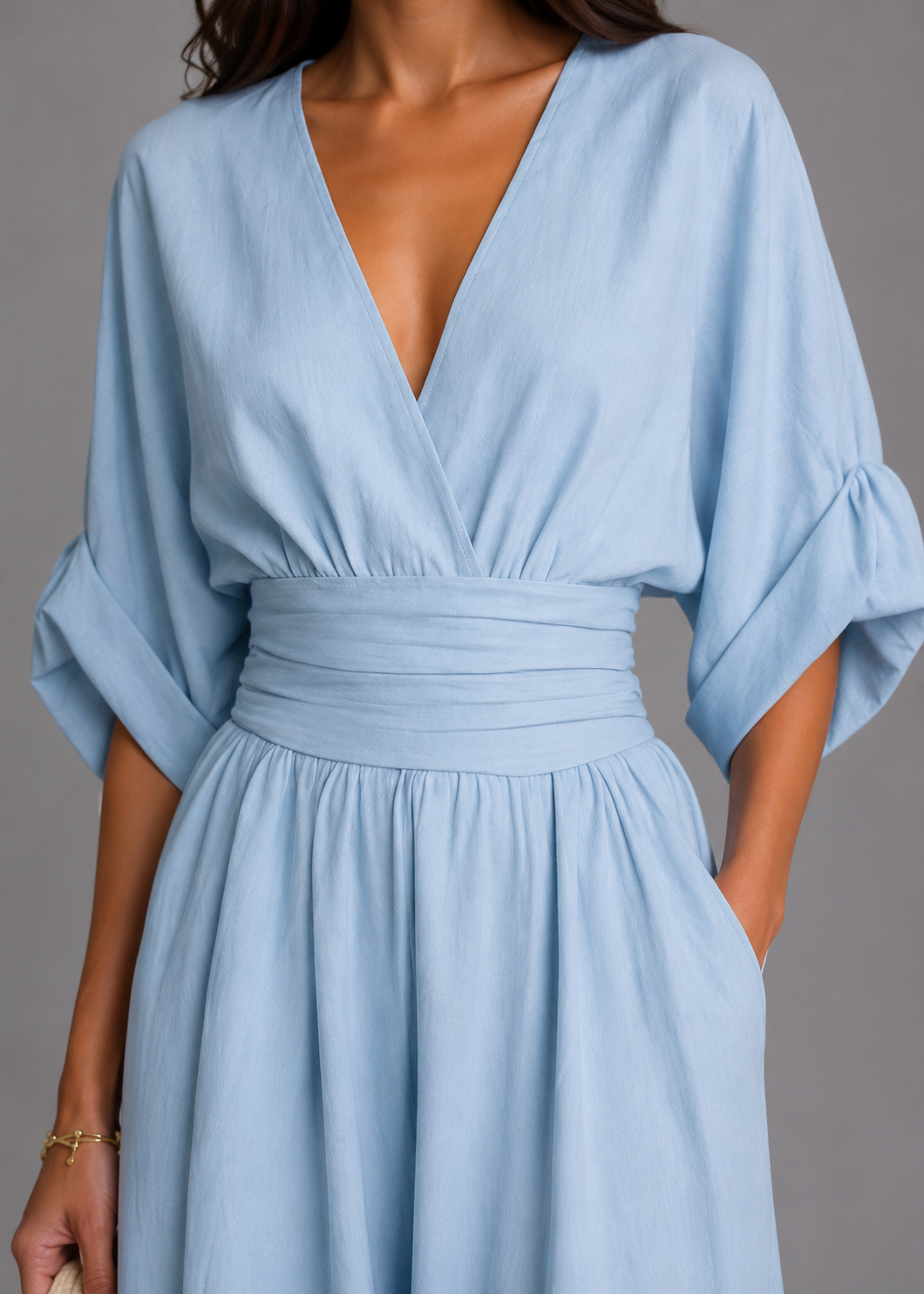 Light blue dress with a V-neck and wide sleeves on a gray background