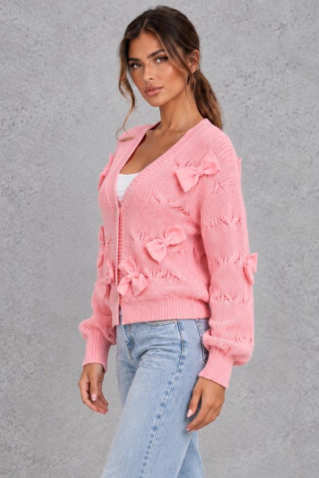 Women’s knitted cardigan with decorative fabric bows, a V-neckline, button front, textured knit finish and slightly cropped silhouette.