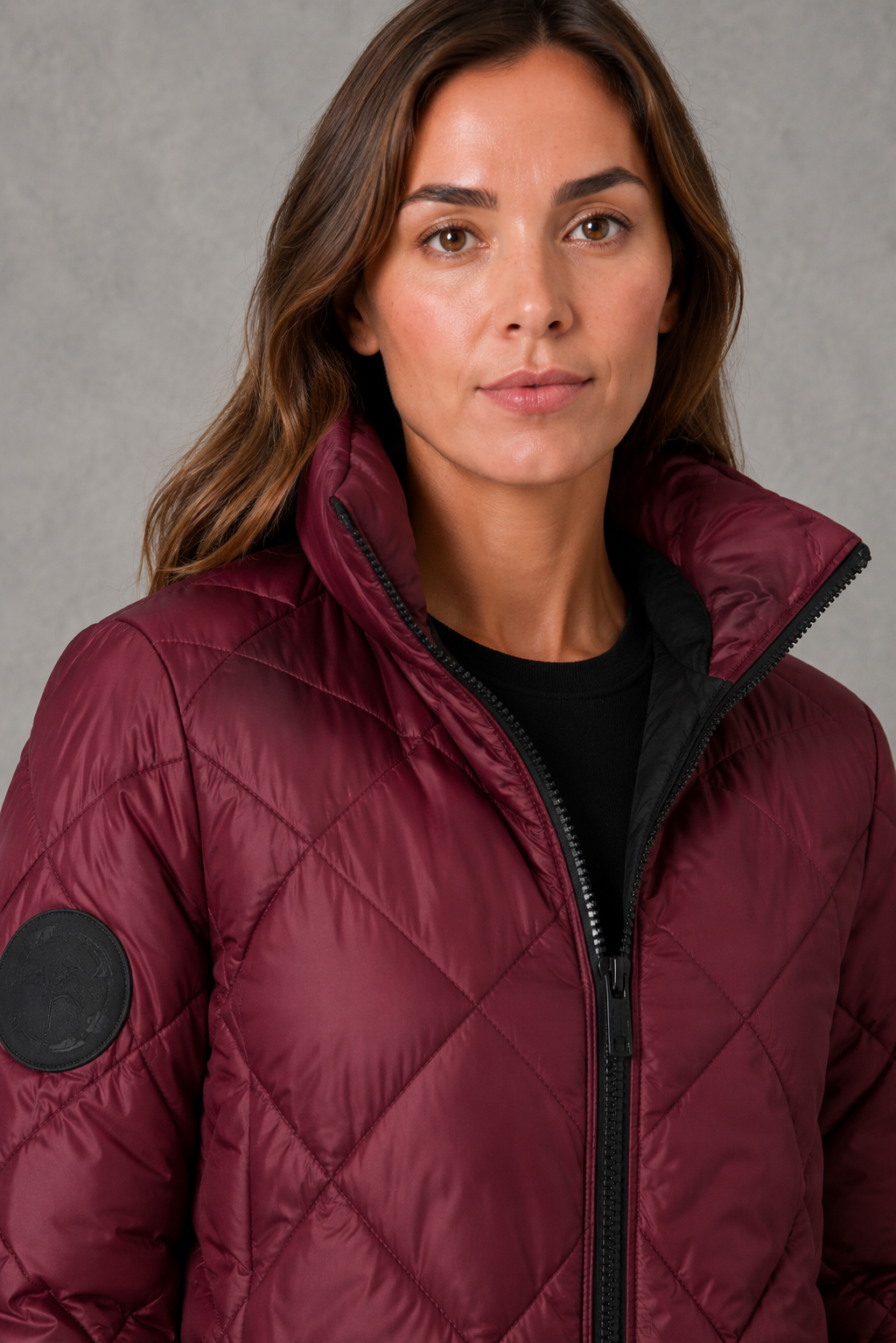 Women’s burgundy quilted puffer jacket with lightweight padding, a high collar, tailored silhouette and practical side pockets for winter wear.