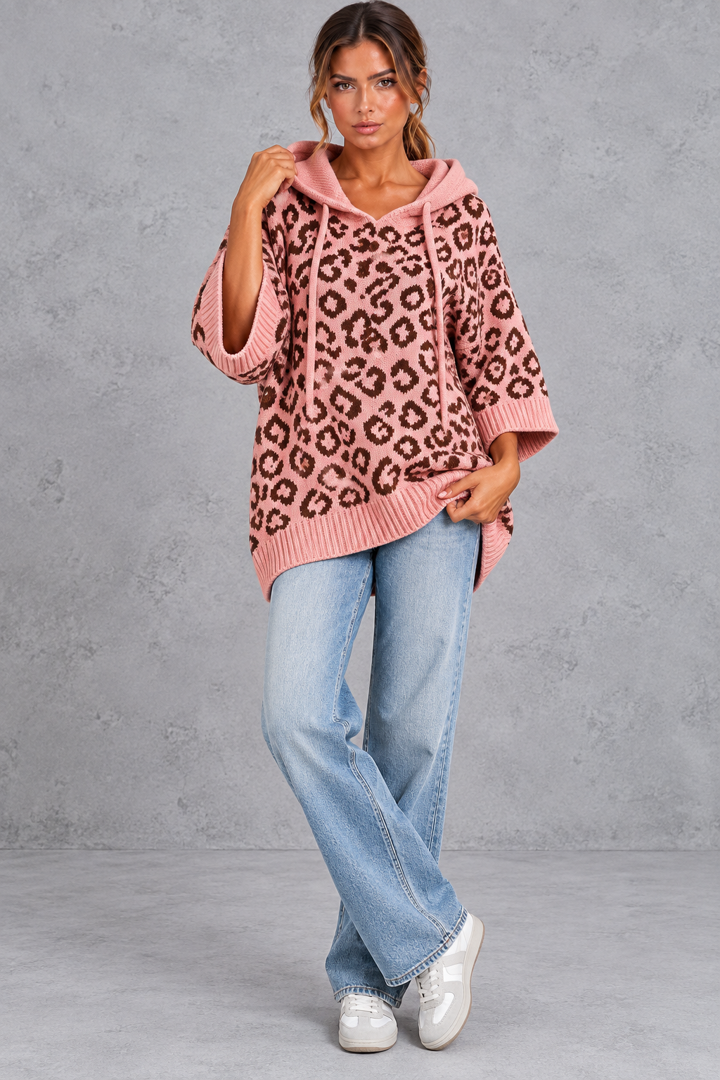 Women's pink leopard print knit hooded jumper styled with jeans – full-length front view