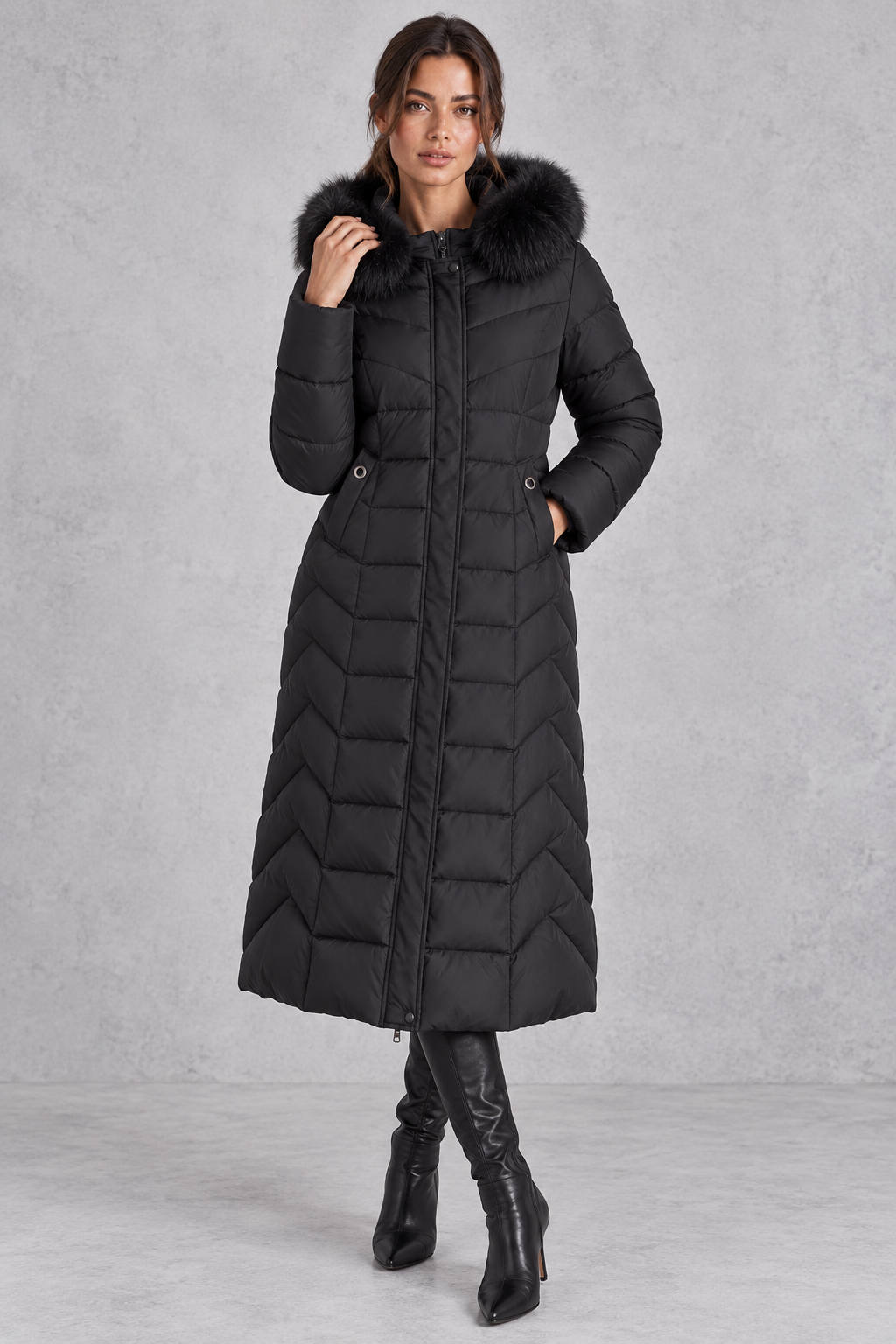 Women’s longline puffer coat with a plush faux fur-trimmed hood, chevron quilting, padded sleeves and a gently defined waist.