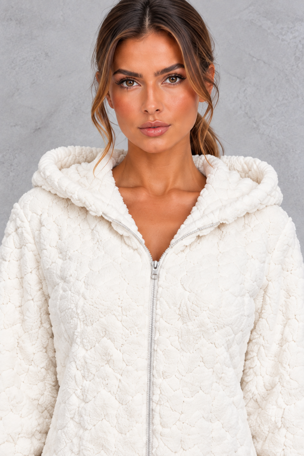 Women’s teddy fleece jumpsuit with a plush fluffy texture, large hood, full-length zip, long sleeves and relaxed one-piece silhouette.