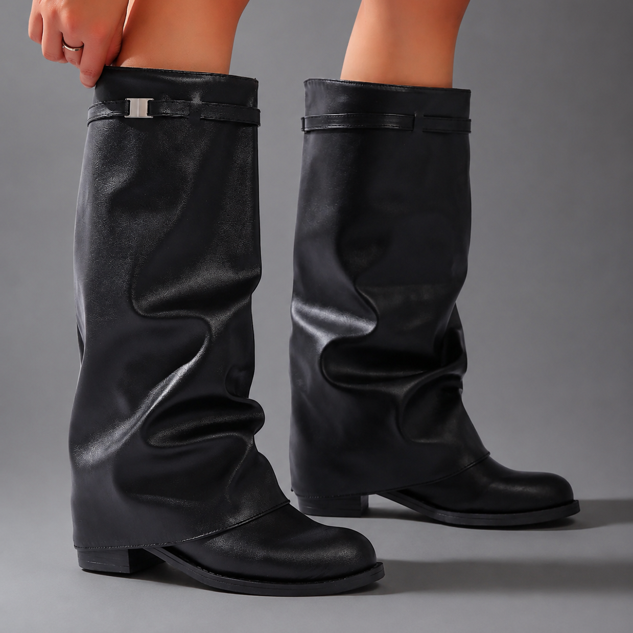Women’s knee-high slouch boots with pointed toe, low block heel and metal cuff detail.