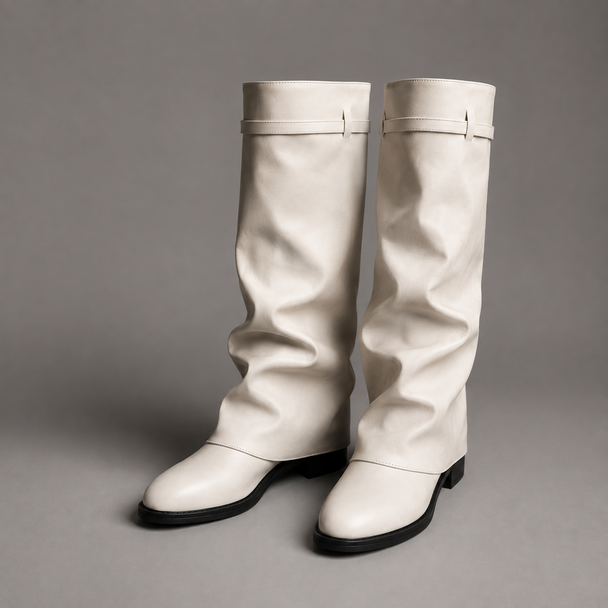 Women’s knee-high slouch boots with pointed toe, low block heel and metal cuff detail.