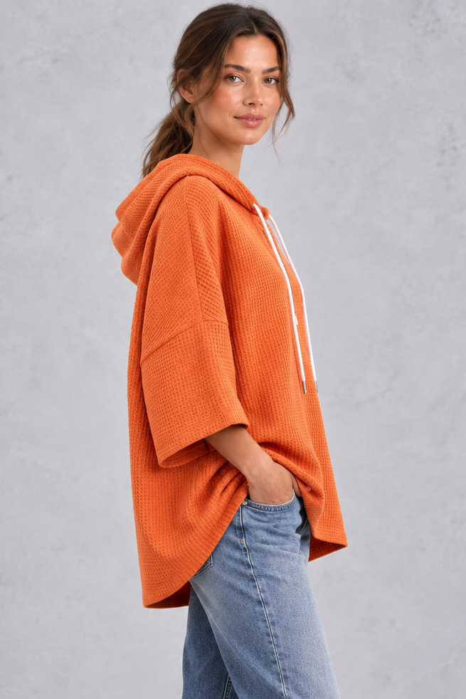 Women's plus size orange waffle knit oversized hoodie with curved high-low hem – side view