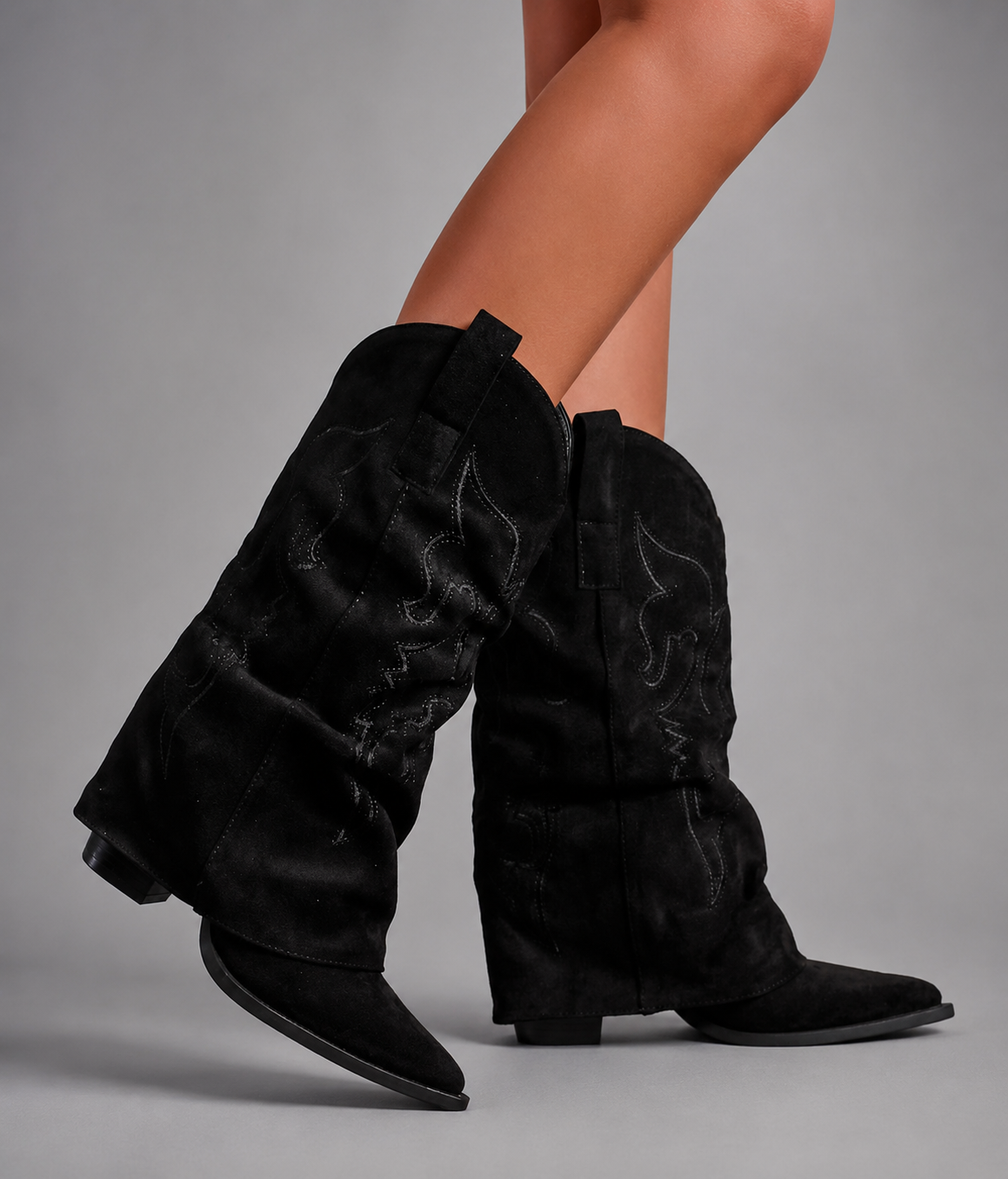 Women’s pointed toe knee high boots with a low chunky heel and relaxed Western-inspired shaft in a neutral shade.