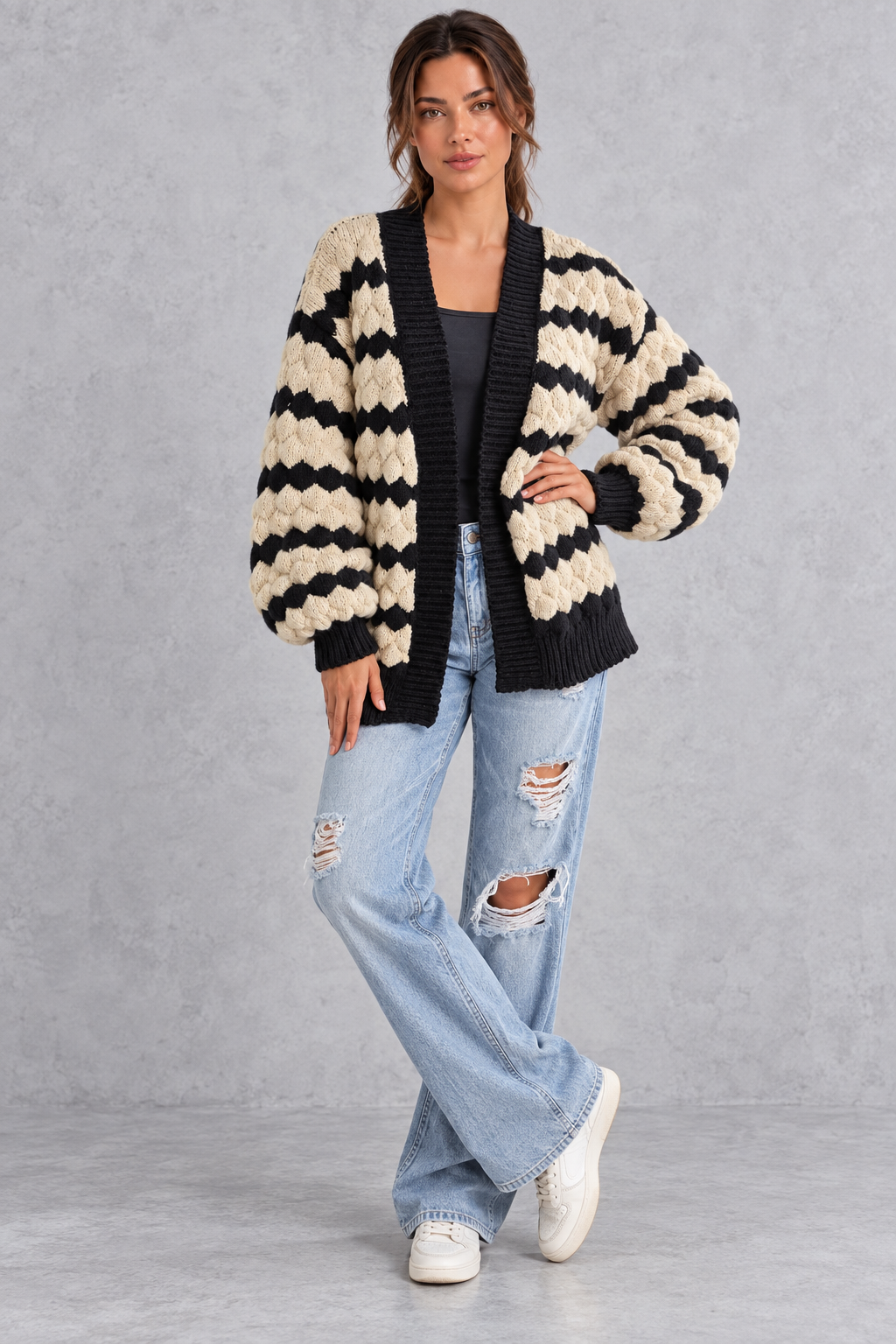 Women's apricot striped chunky knit cardigan with puff sleeves – full-length front view with jeans