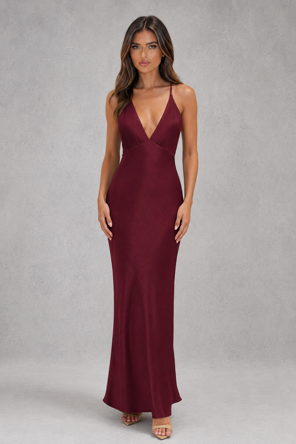 Woman wearing a burgundy evening gown against a gray background