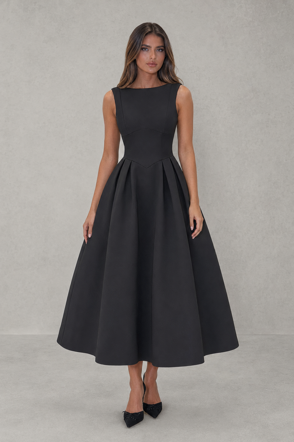 Woman wearing a black sleeveless dress against a gray background