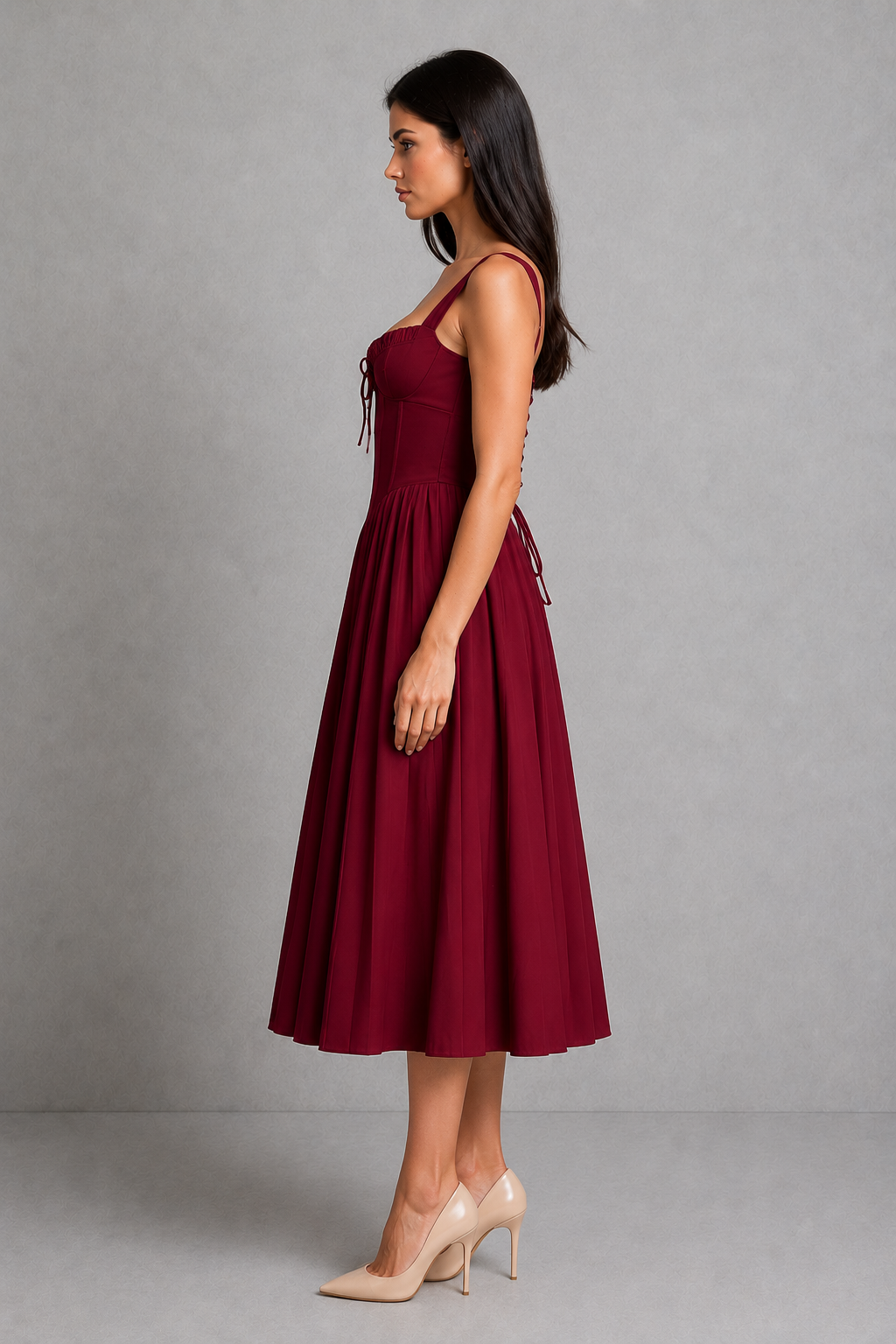 Woman wearing a burgundy dress against a gray background