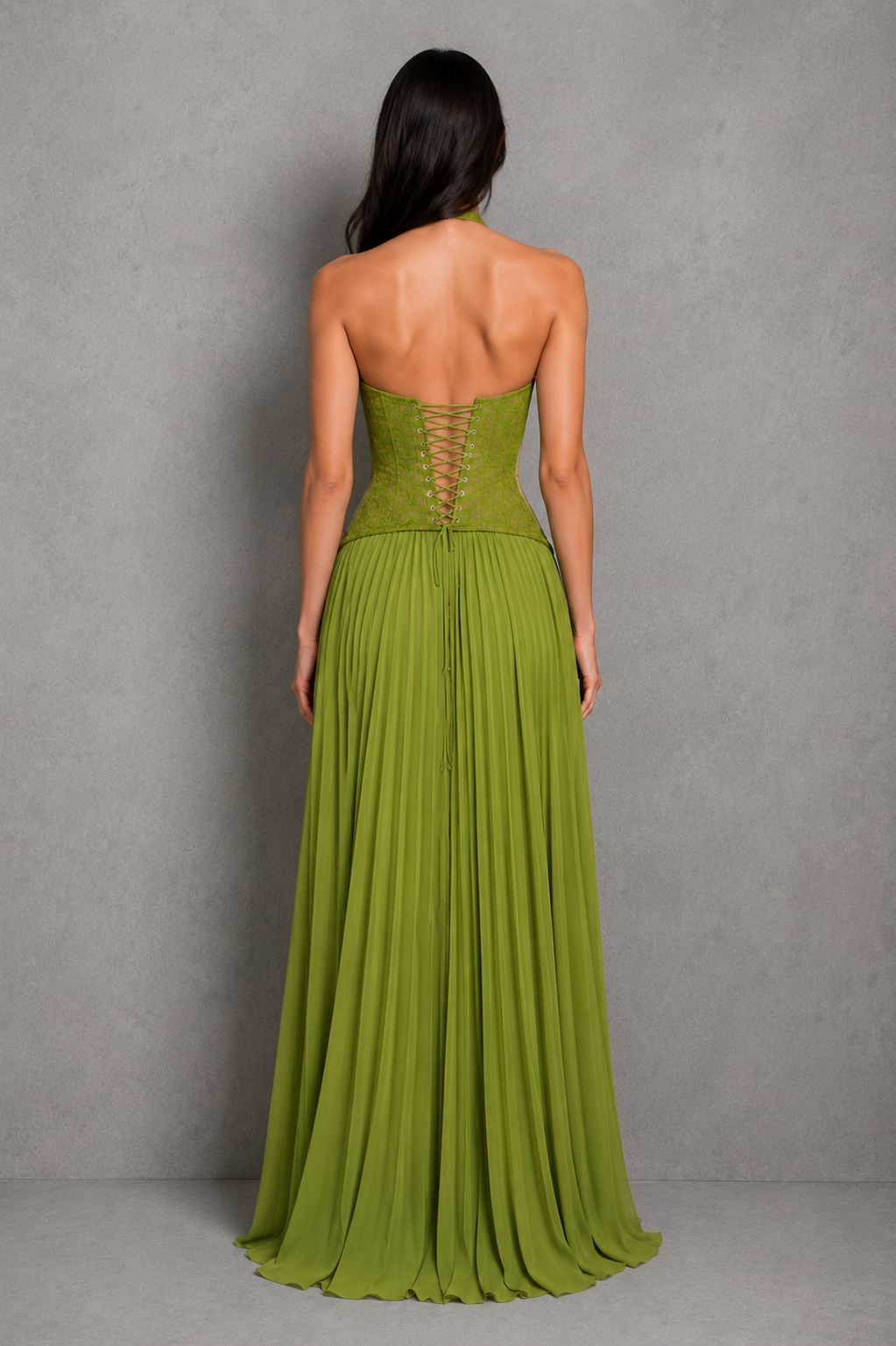 Woman wearing a green strapless gown against a gray background