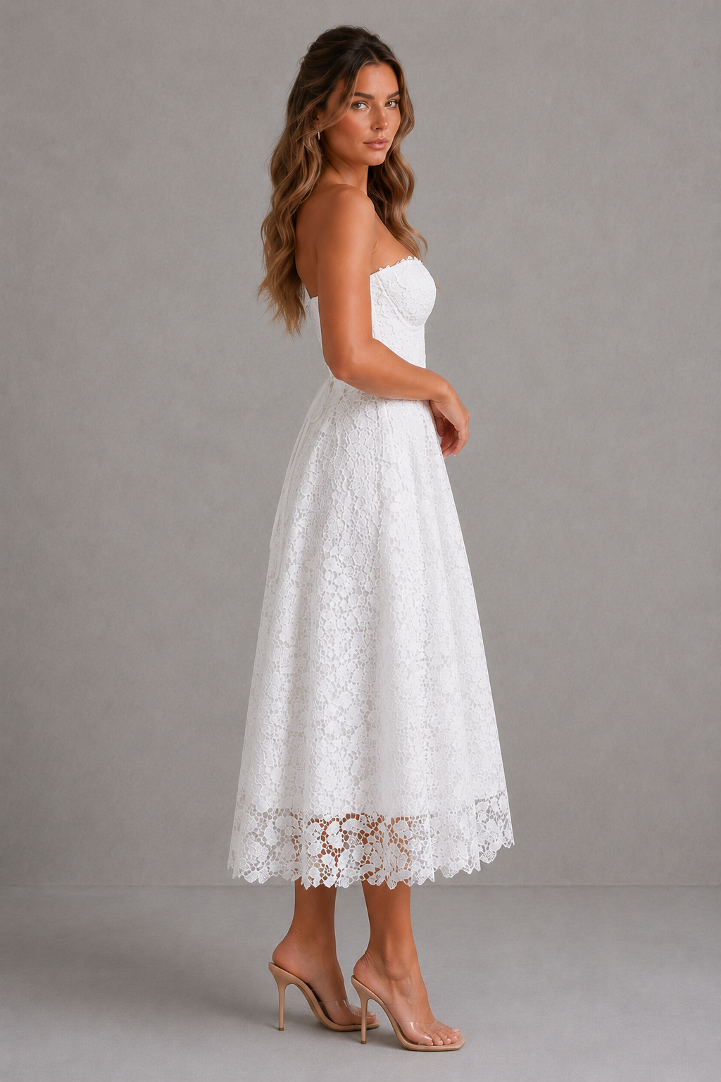Woman wearing a white lace dress against a gray background