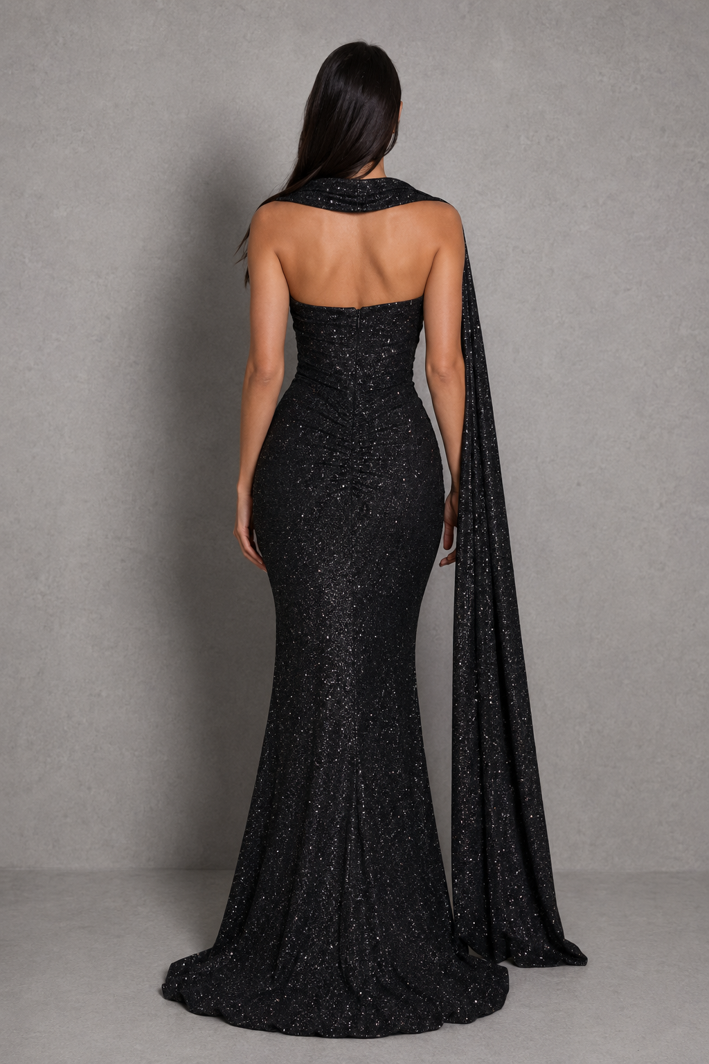 Black evening gown with cape on a gray background