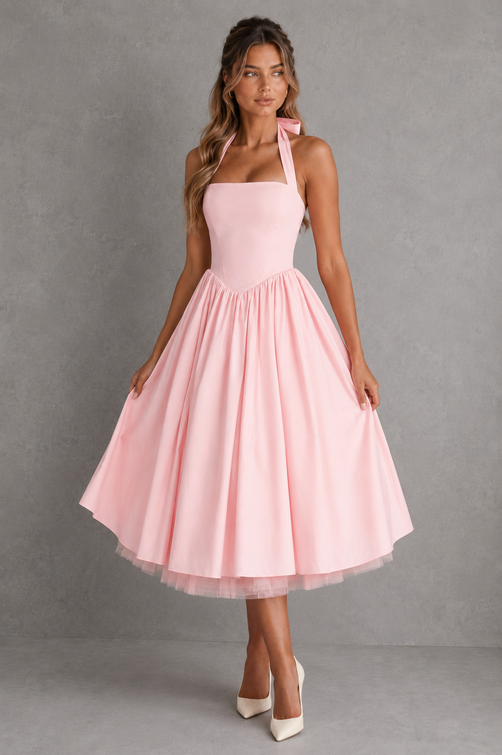 Woman wearing a pink dress against a gray background