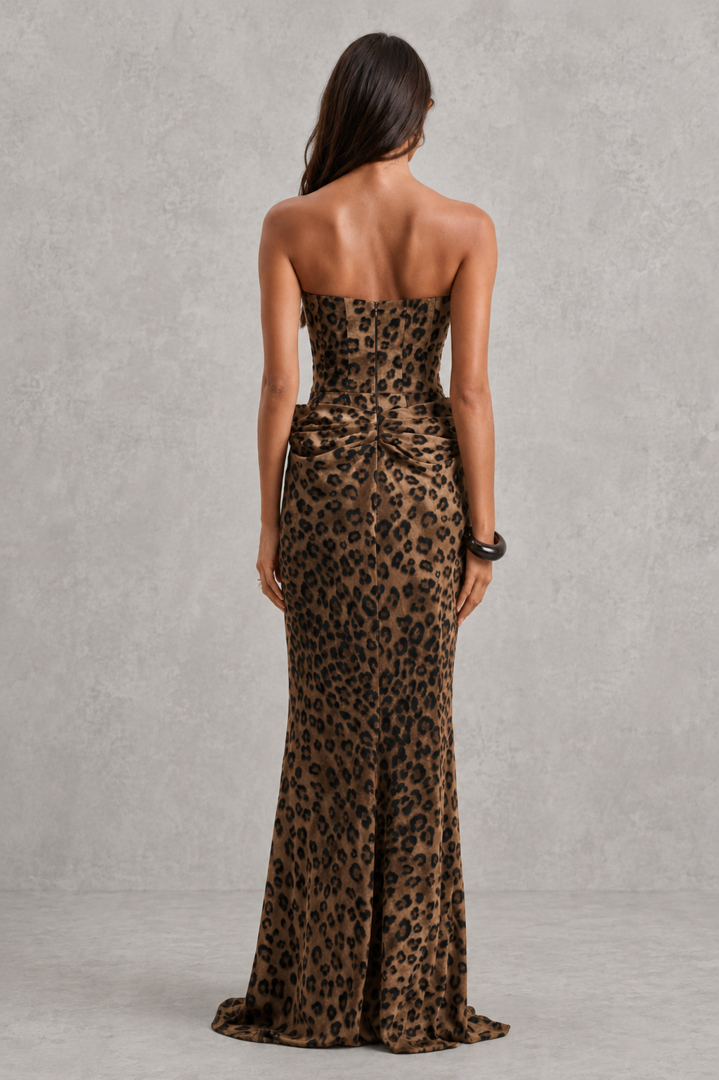 Woman wearing a strapless leopard print gown against a gray background