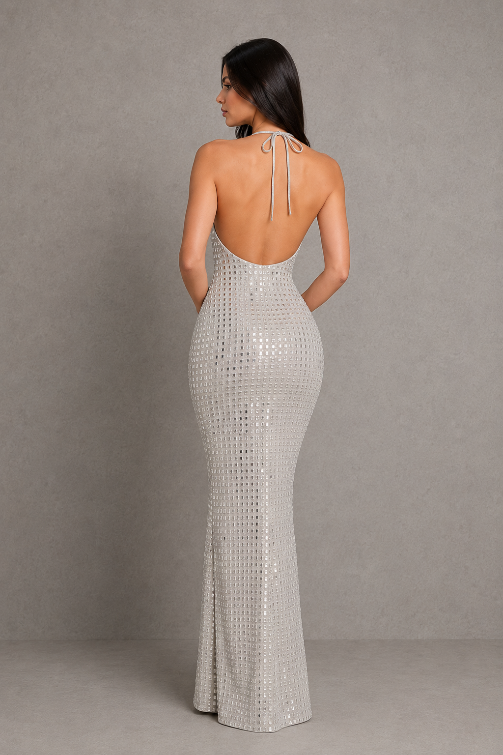 Woman wearing a silver sequin gown against a gray background