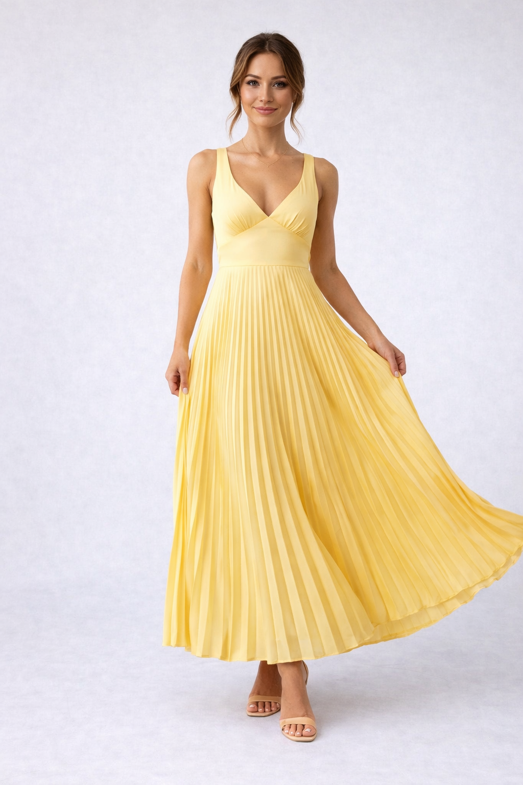 Woman wearing a yellow pleated dress on a white background