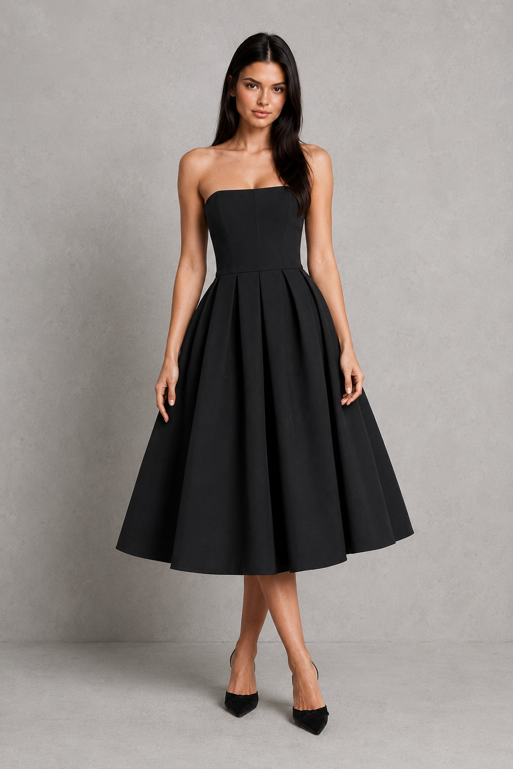 Woman wearing a black strapless dress against a gray background