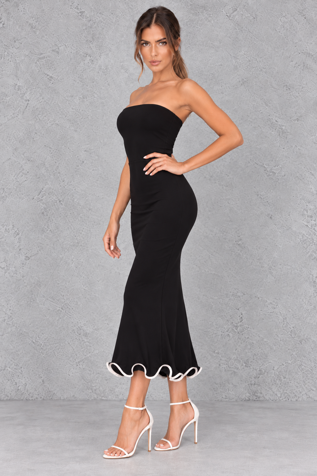 Women’s strapless ruched bodycon midi dress with wrap-style detailing, a fitted silhouette and feminine ruffle hem.
