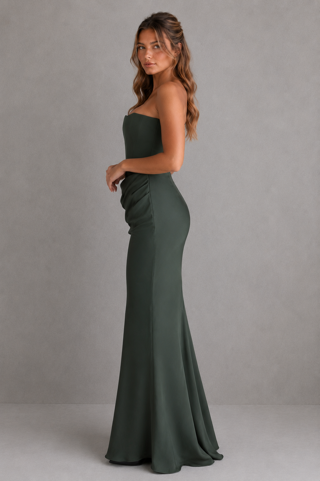 Woman wearing a green strapless gown against a gray background