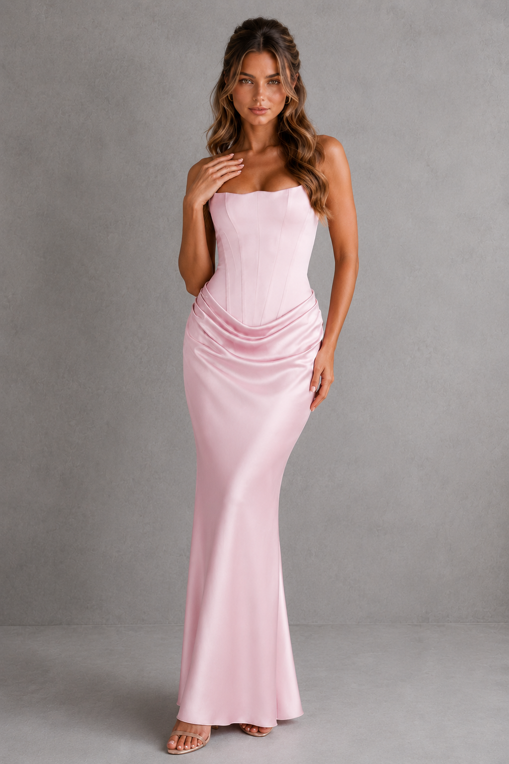 Woman wearing a pink strapless gown against a gray background