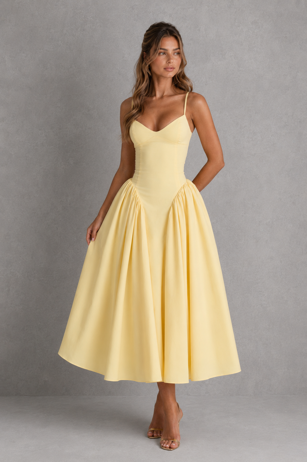 Woman wearing a yellow dress against a gray background
