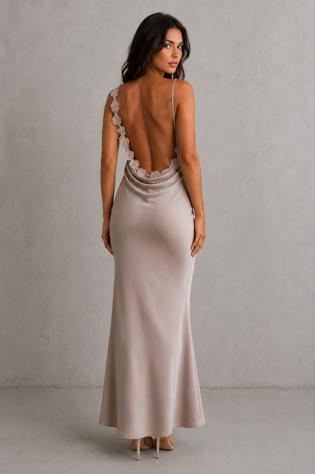 Woman wearing a elegant dress with open back against a plain background