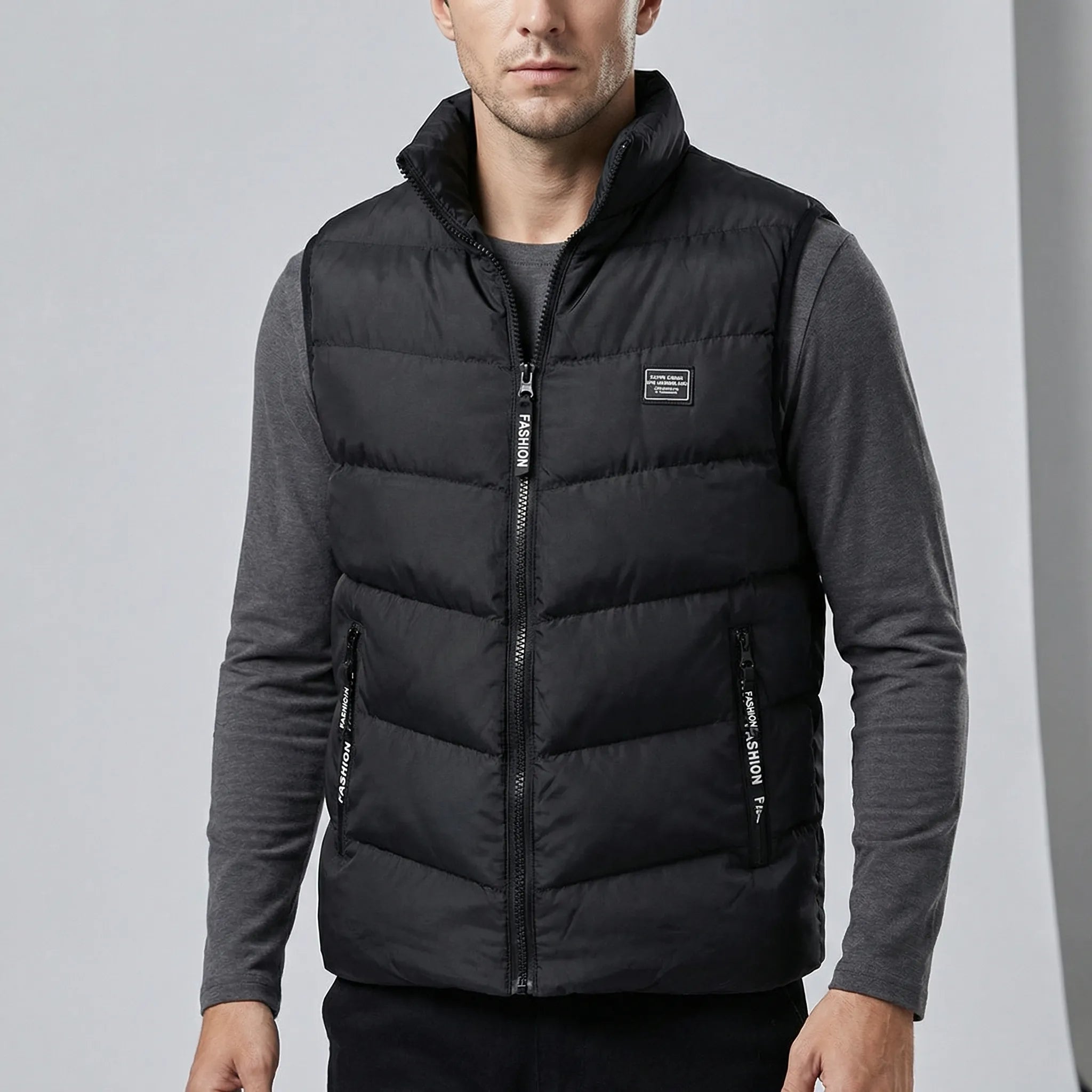 Man wearing a black puffer vest over a gray shirt on a light gray background1