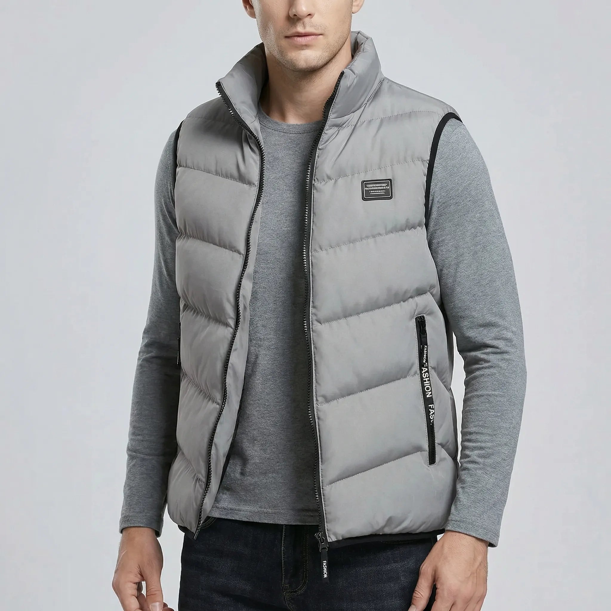 Man wearing a grey puffer vest on a light gray background