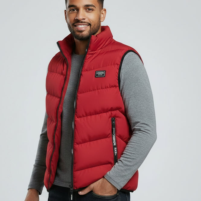 Man wearing a red puffer vest over a gray shirt on a light gray background