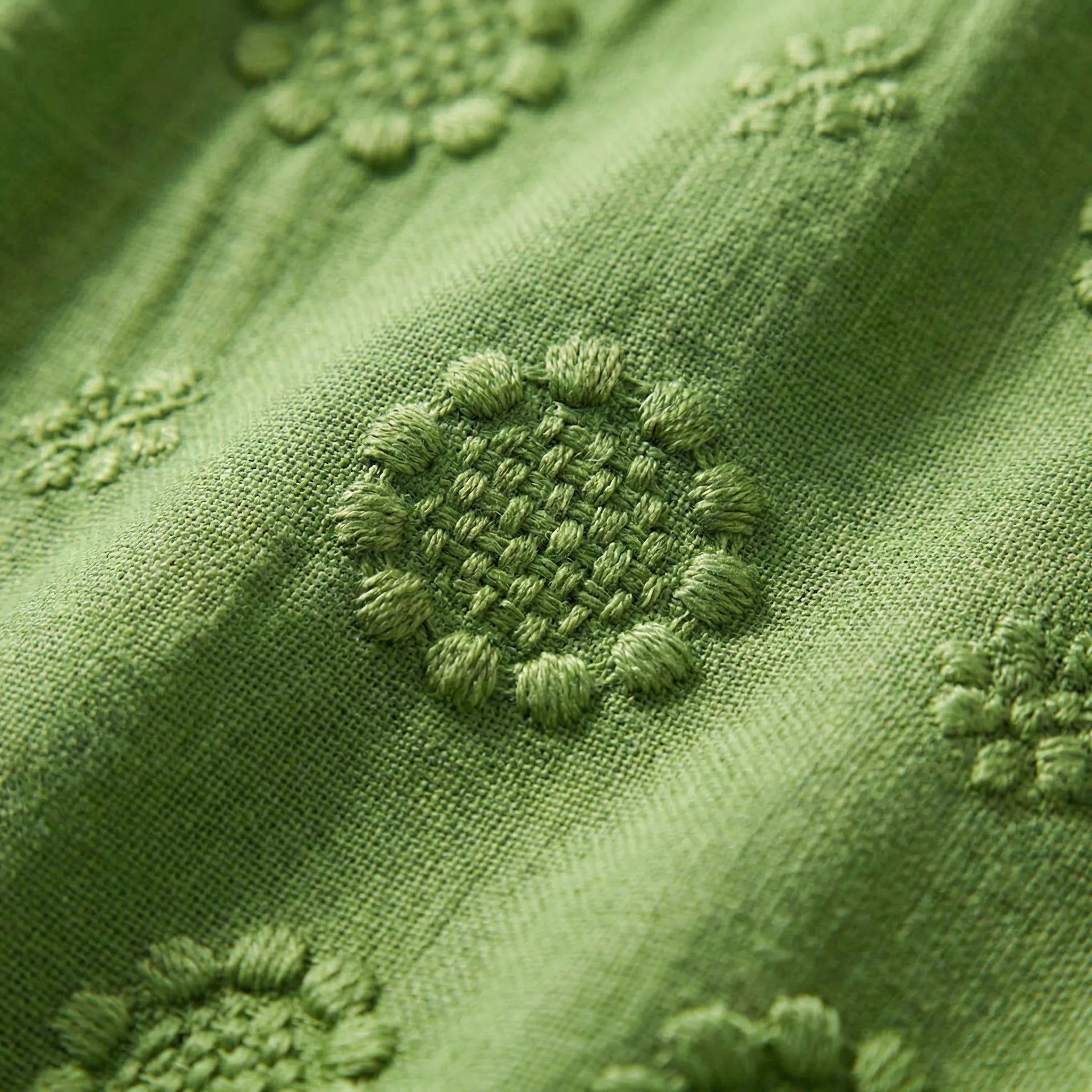 Close-up of green fabric with embroidered patterns2