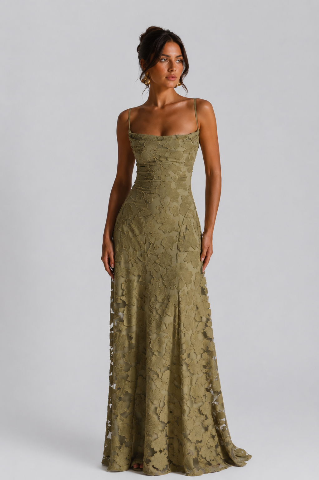 Woman wearing a green lace dress against a gray background