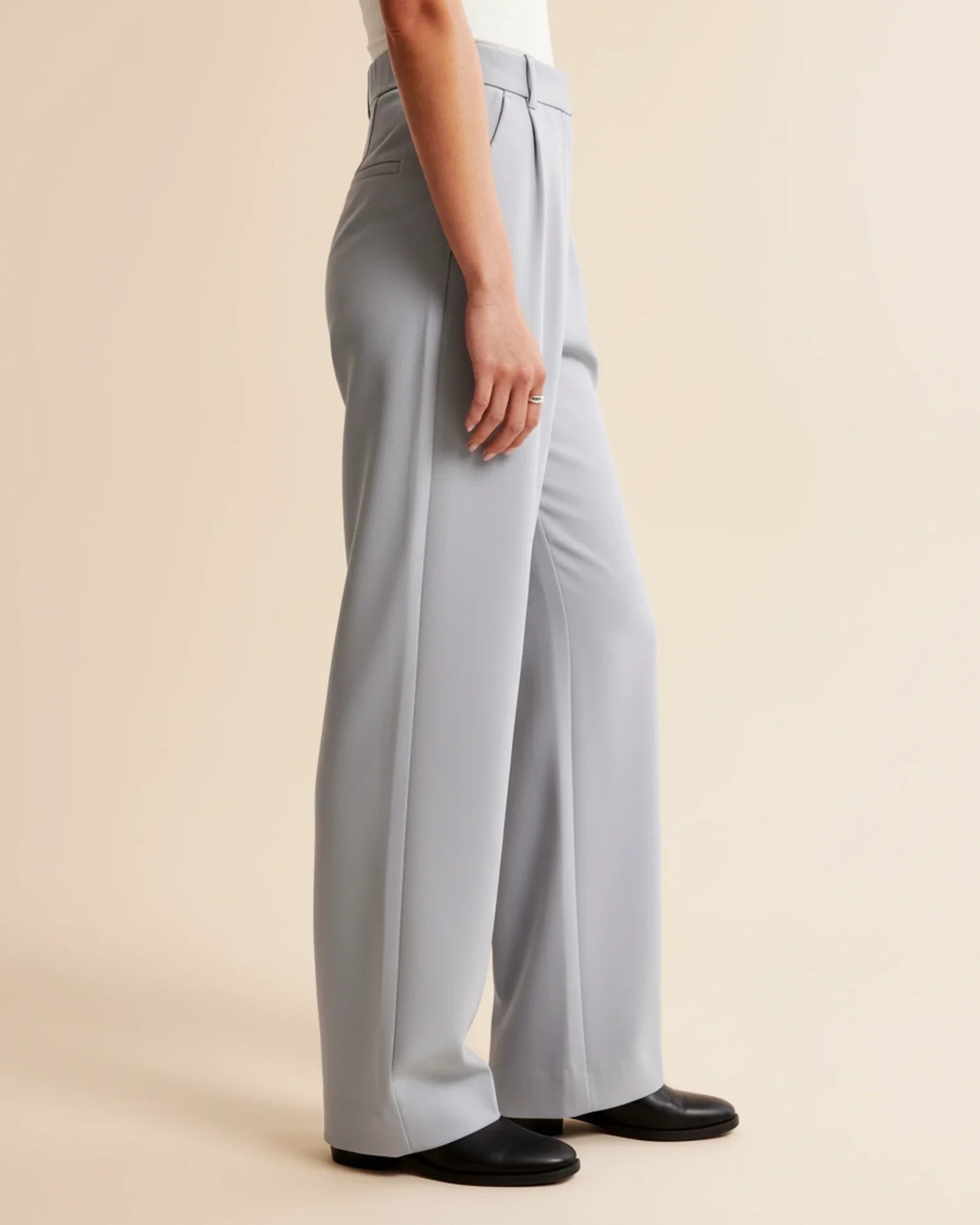 Light gray wide-leg pants worn by a person on a beige background