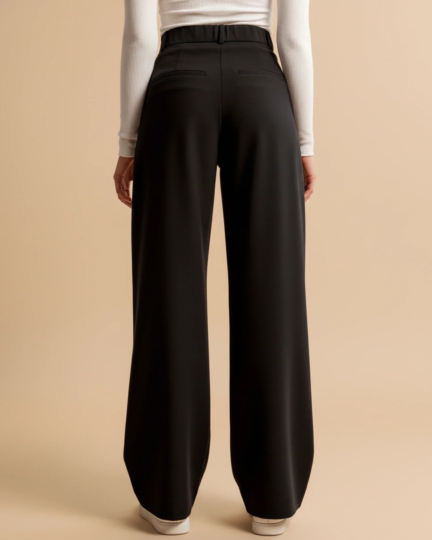 Black wide-leg pants worn by a person on a beige background