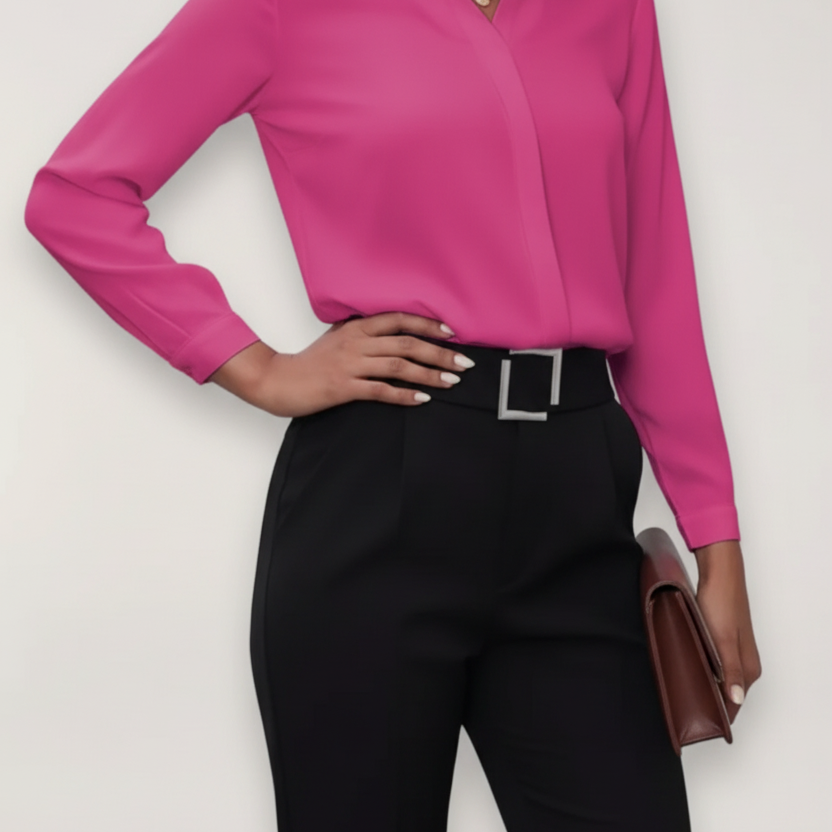Person wearing a bright pink shirt and black pants against a white background