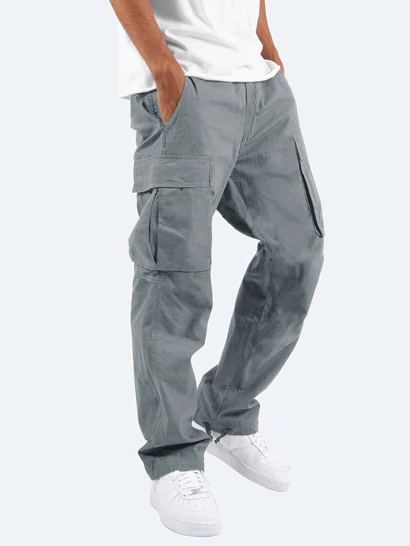 Person wearing gray cargo pants on a white background