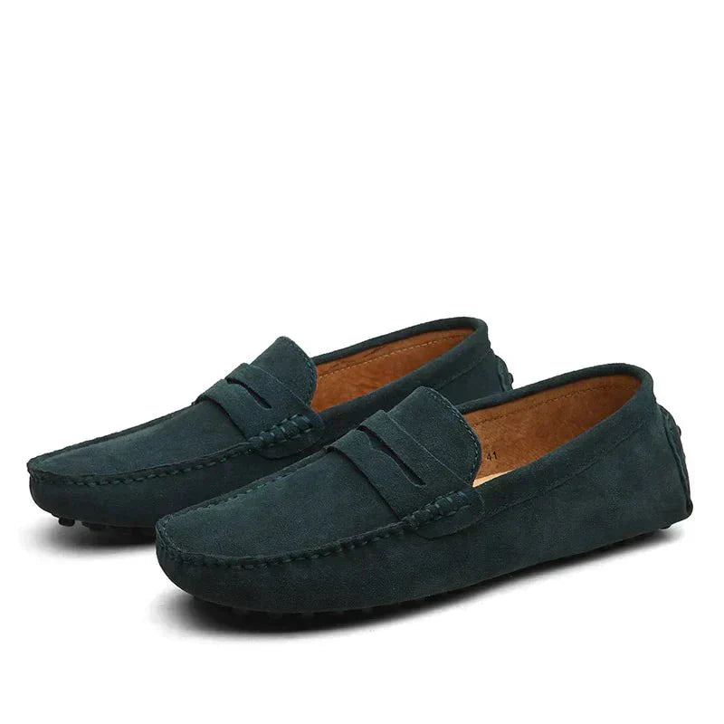 Pair of dark green loafers on a white background