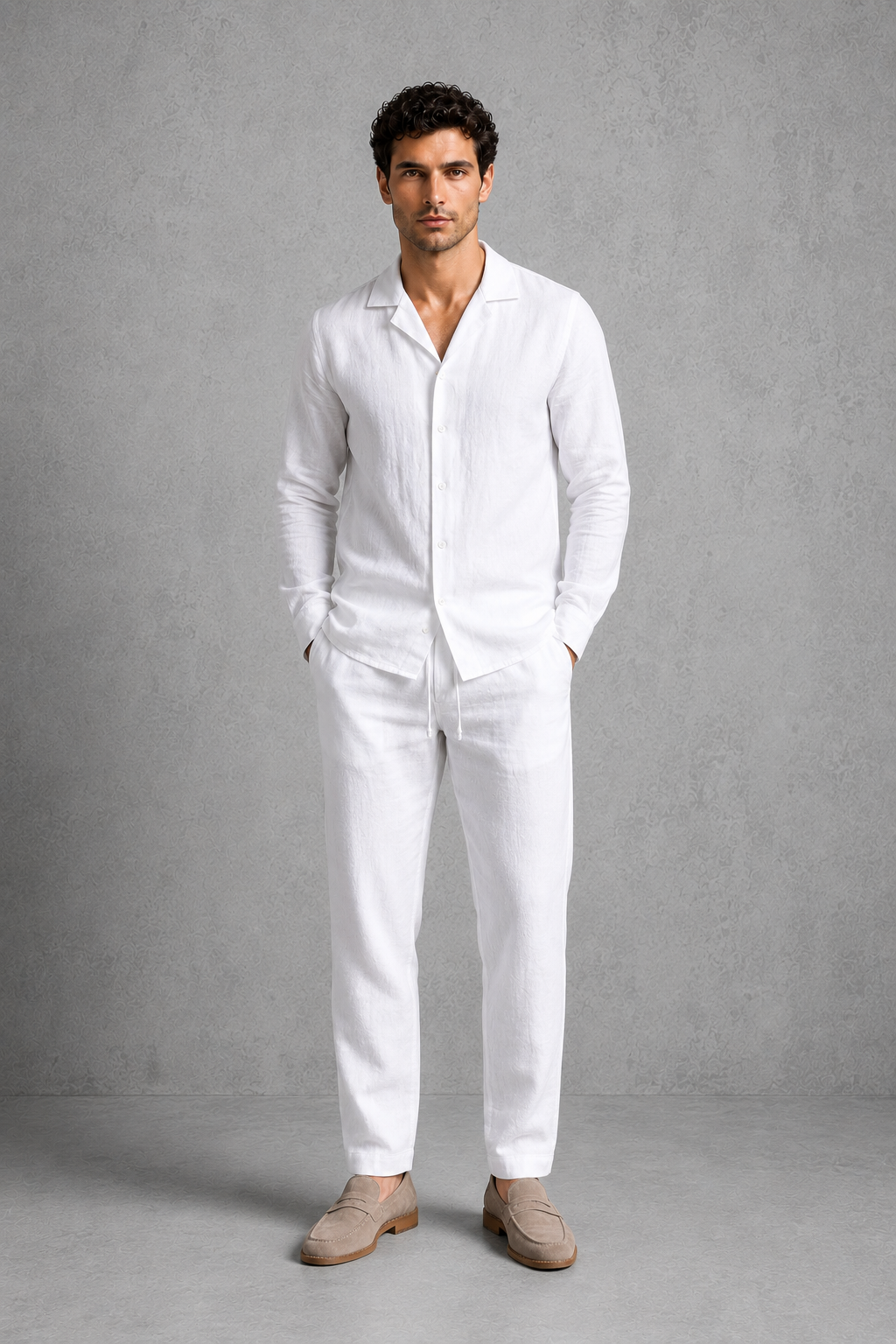 Man wearing a white linen suit against a gray background