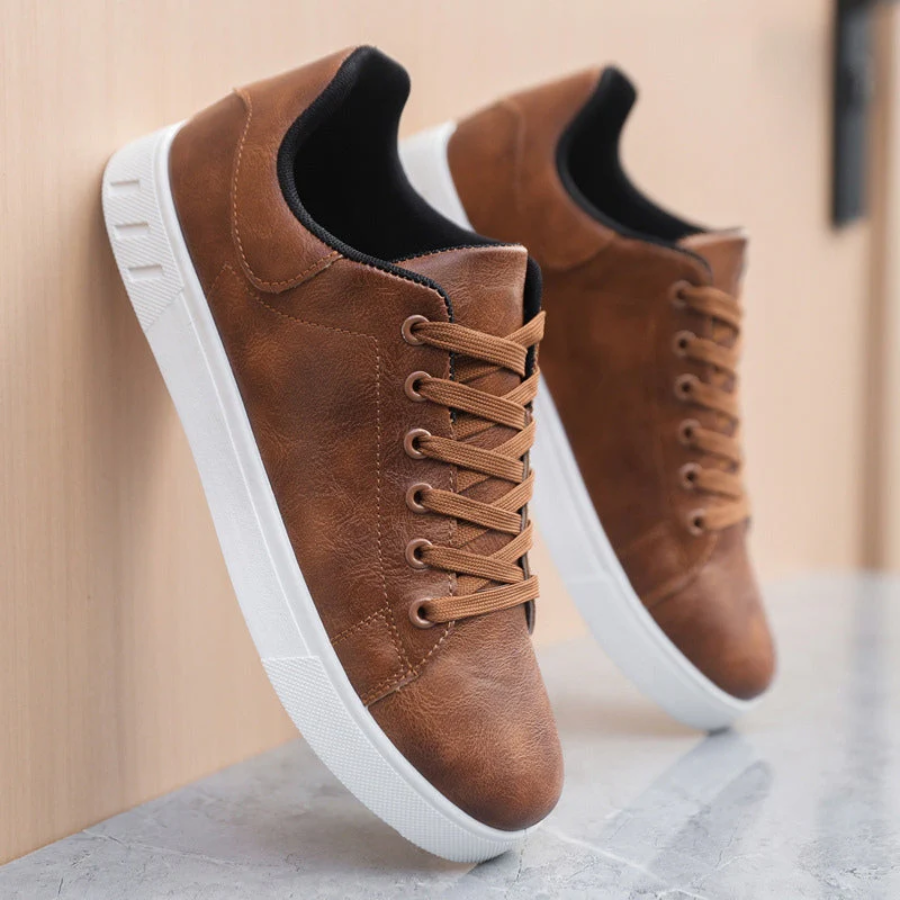 Brown leather sneakers with white soles on a neutral background