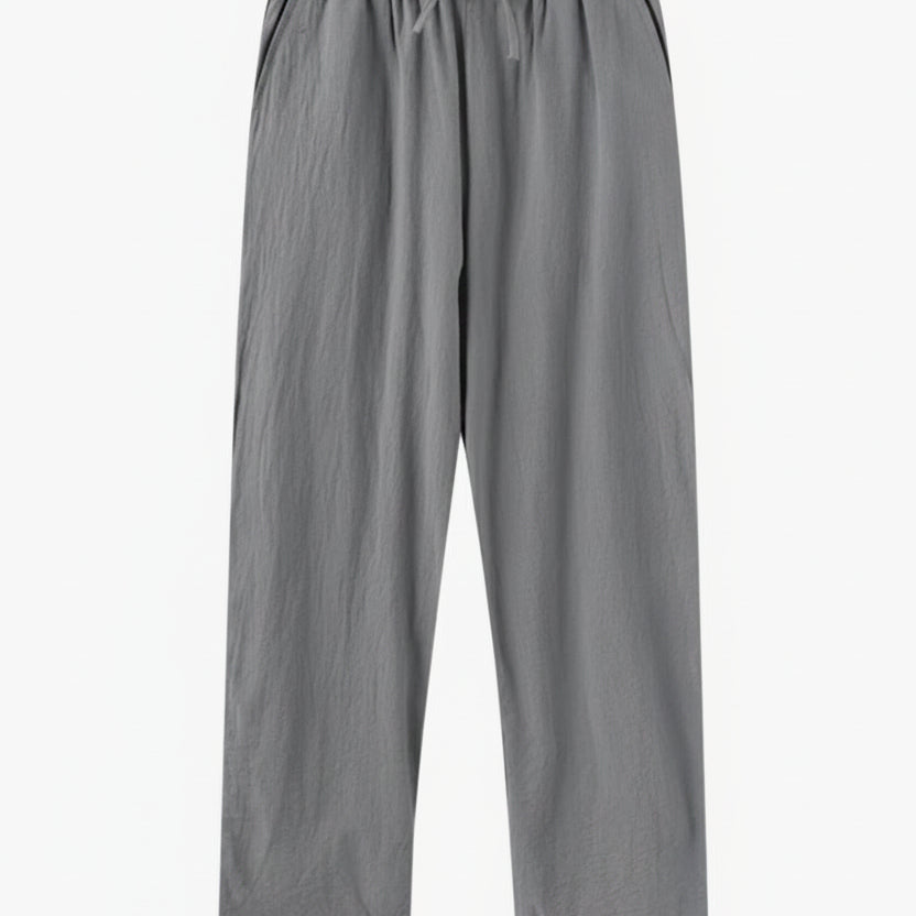 Gray pants on a wooden hanger against a white background