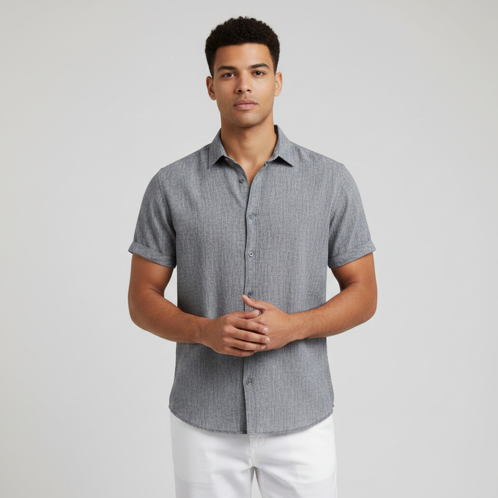 Man wearing a gray short-sleeve button-up shirt and white pants on a light background