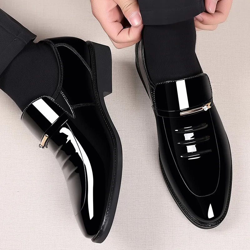 Black shiny dress shoes being worn on a neutral background