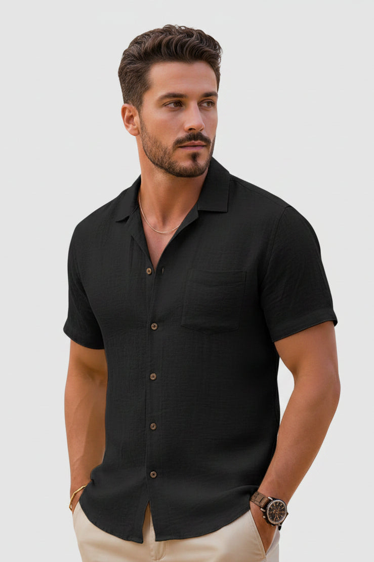 Man wearing a black short-sleeve shirt on a light gray background