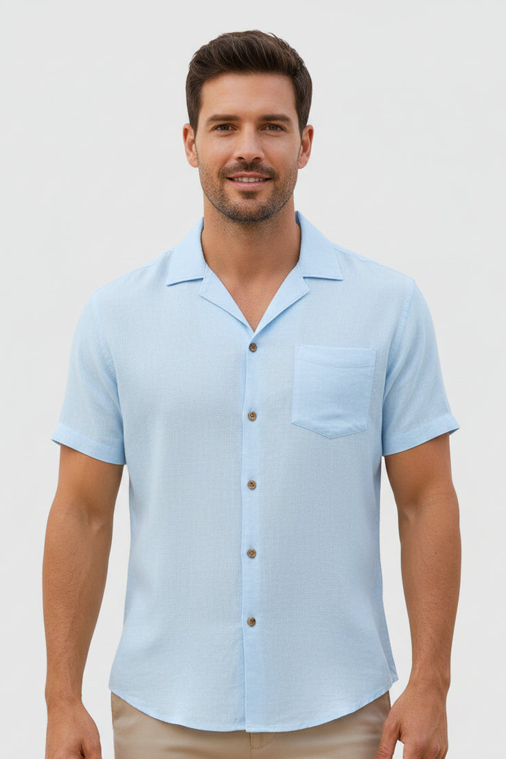 Man wearing a light blue short-sleeve shirt on a plain background