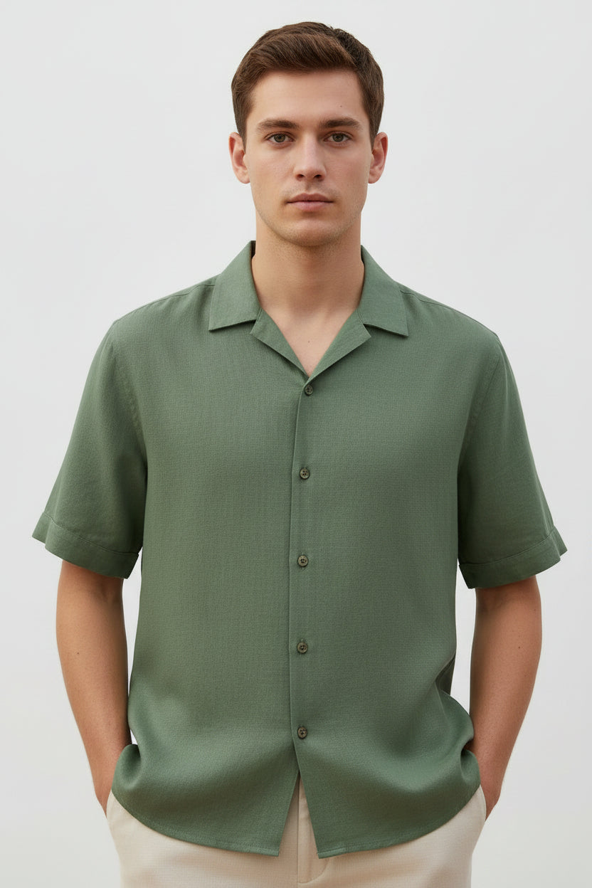 Man wearing a green short-sleeve shirt on a light gray background