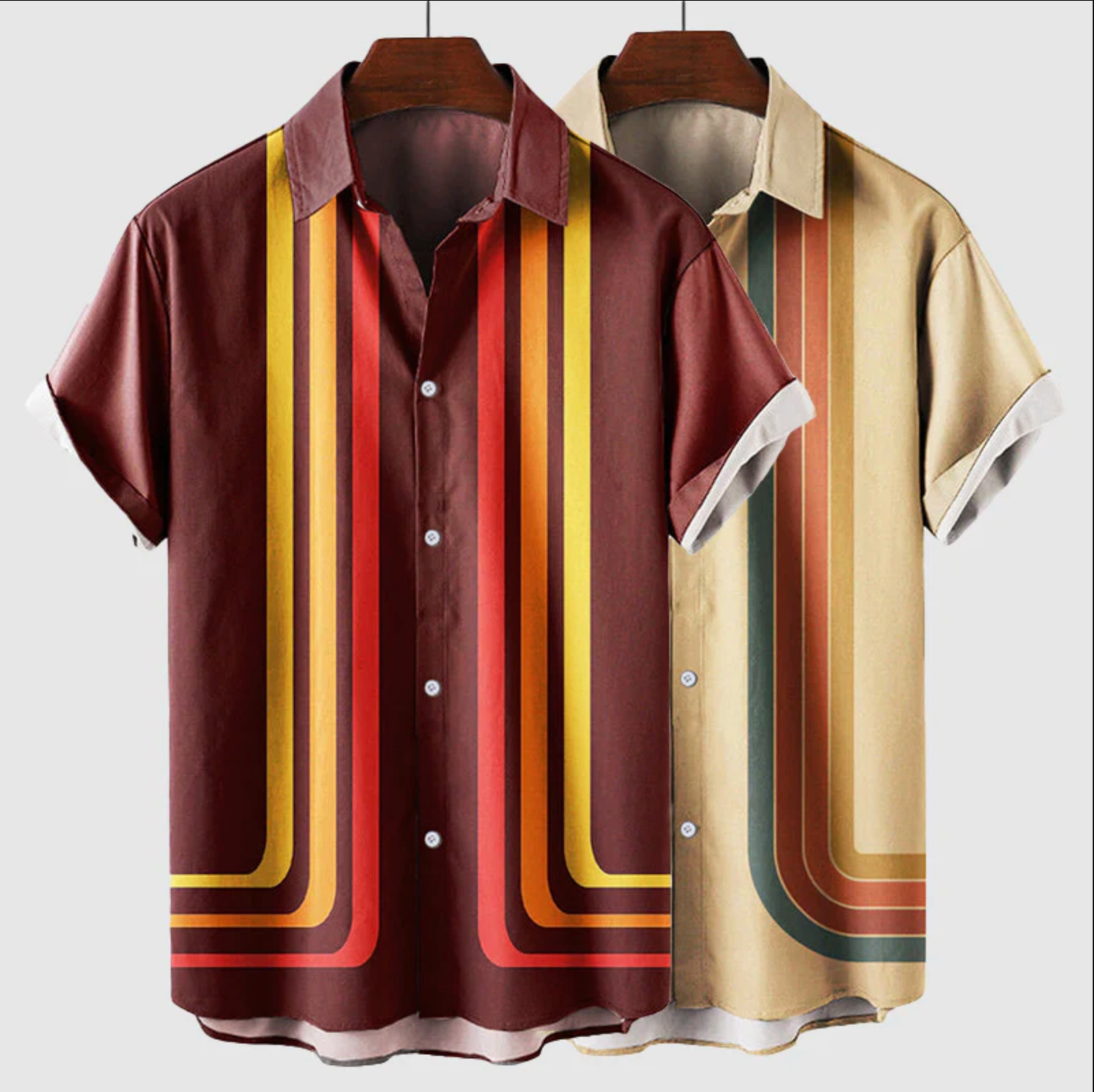 Two short-sleeve shirts with colorful striped patterns on hangers against a white background.