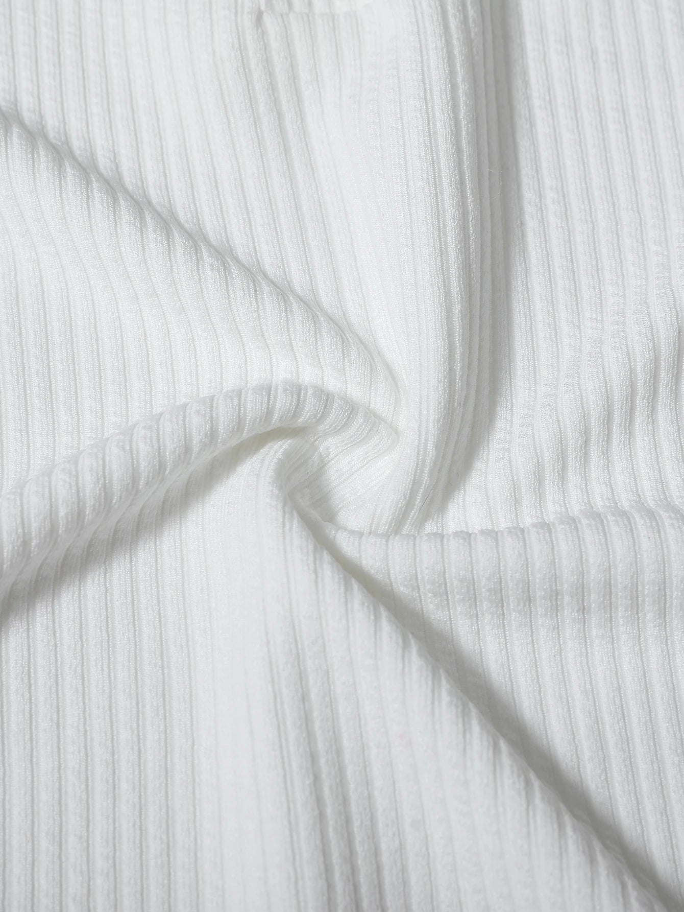 Close-up of white ribbed fabric with folds