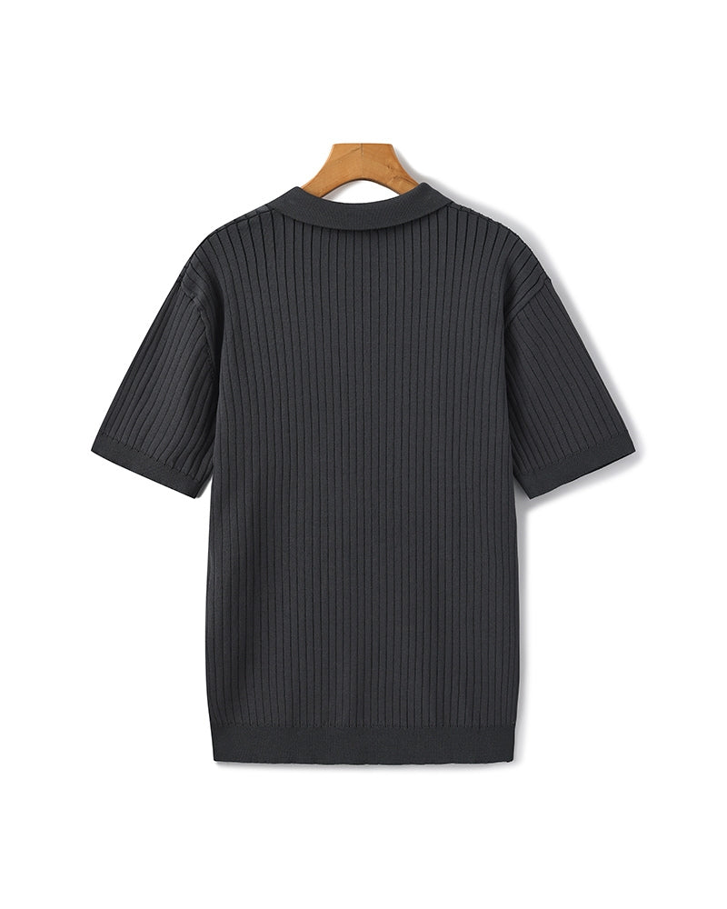 Black ribbed sweater on a wooden hanger against a white background
